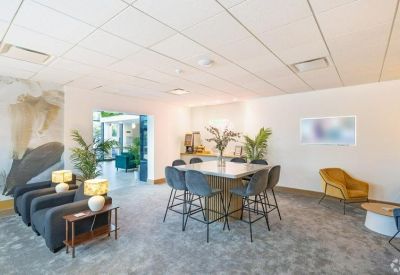 Coworking lounge with a large high-top table and various modern seating options.