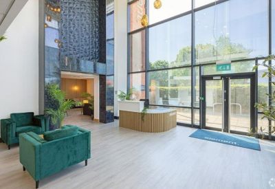 Double-height reception area with blue feature walls and velvet armchairs.