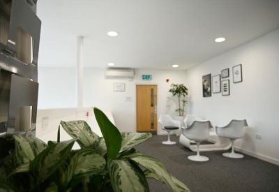 Cozy break area with modern white chairs and framed wall art.
