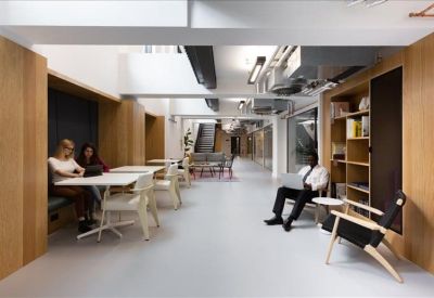 Communal breakout area with wooden wall panels and cafe-style seating.