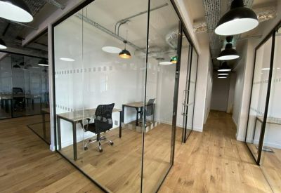 Private glass-enclosed office pods with individual desks and ergonomic chairs.