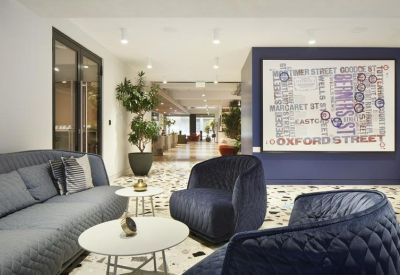 Lounge area with blue velvet armchairs, terrazzo flooring, and a large Oxford Street map artwork.