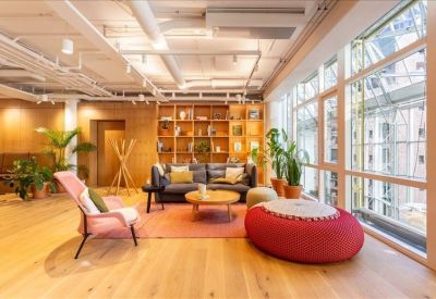 Spacious communal lounge with comfortable seating, colorful rugs, and a large bookshelf.