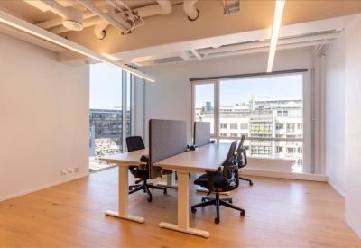 Private office suite featuring height-adjustable desks and views of the city.