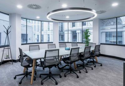 Bright conference room with a large ring-shaped light fixture and grey carpet.