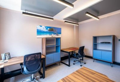 Small office suite with two desks and blue-fronted storage units.
