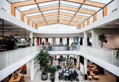 Wide view of a modern office atrium featuring multiple floors of glass-walled workspace.