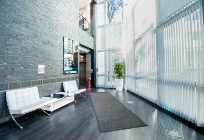 Bright lobby area with stone feature walls, white seating, and large windows.