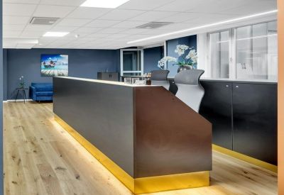 Sleek dark reception desk with warm under-lighting and wood flooring.