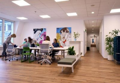 Large meeting room with a long white table, various ergonomic chairs, and colorful wall art.