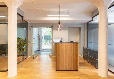 Reception area featuring a slatted wood desk, white columns, and glass partitions.
