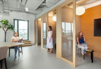 Private glass-walled focus booths and informal meeting area.