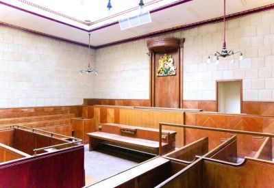 Traditional wood-paneled courtroom style chamber with bench seating and ornate crest.