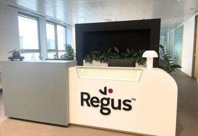 Branded reception desk with clean lines and indoor greenery.