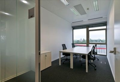 Small meeting room with a white table and black mesh chairs.