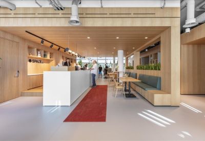 Spacious reception and communal lounge at Grafenauweg 8, Zug, Switzerland with wood paneling and red runner rug.