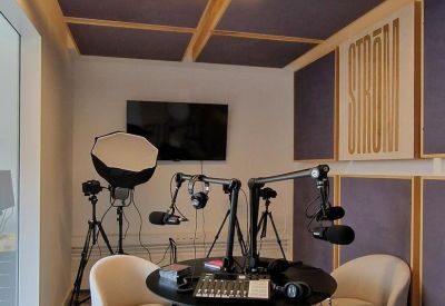Podcast and media studio with soundproofing panels and professional microphones.