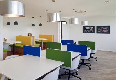 Modern wooden dining booths with lime green and yellow cushioned seating.