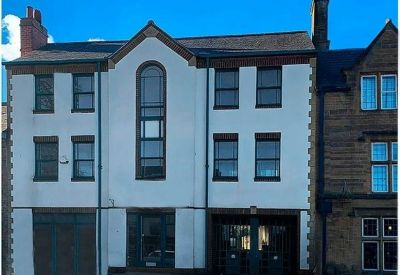 The exterior white facade of Guardian House, 7 North Bar Street, Banbury with dark framed windows.