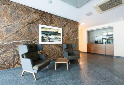 Lobby area with modern chairs and a decorative wall.