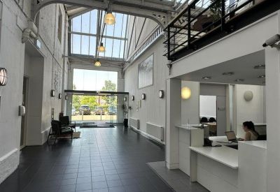 Bright white reception lobby with high ceilings and glass doors.