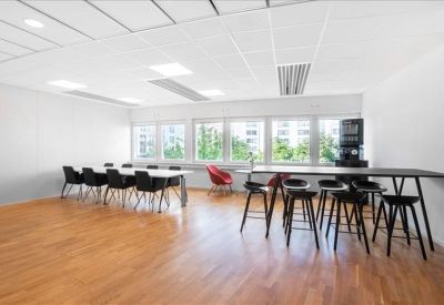 Spacious breakroom with wooden floors and a variety of seating options.