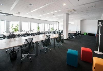 Spacious open-plan office with colorful seating.
