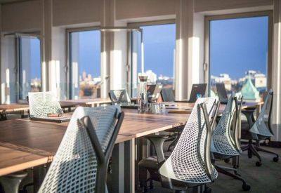 Meeting room with laptops and a glass water bottle on the table.