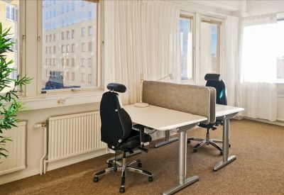 Two-person office suite with white desks and black ergonomic chairs.
