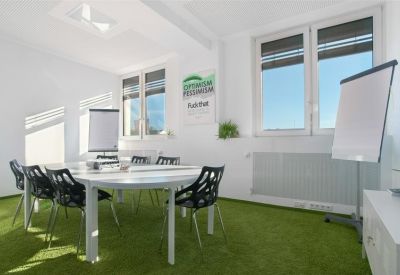 Meeting room with artificial grass flooring and flip charts.