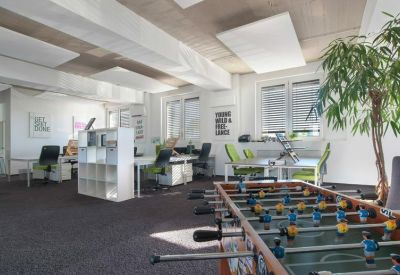 Large office lounge area featuring a foosball table and shelving units.