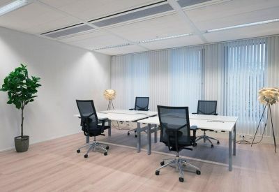 Private four-desk office suite with light wood floors and large windows.