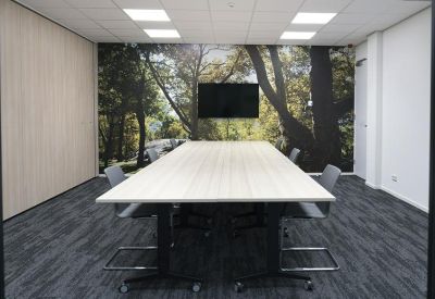 Professional meeting room featuring a long white table and a nature-inspired wall mural.