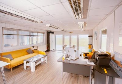 Bright communal lounge featuring a vibrant yellow sofa and a modern coffee table.