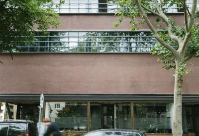 Exterior view of the dark brick building at Hauptstraße 78-79, Berlin with large industrial windows.
