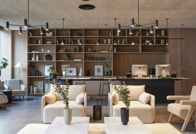 Reception area with a wooden bookshelf wall and plush armchairs.