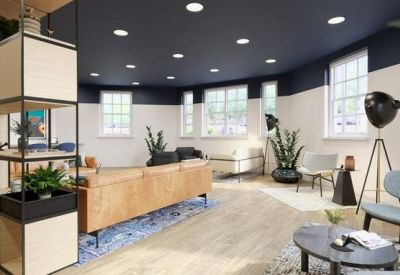 Bright breakout area with a large wooden shelving unit, comfortable seating, and large windows.