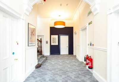 Spacious corridor featuring a dark blue accent wall and several white doors.