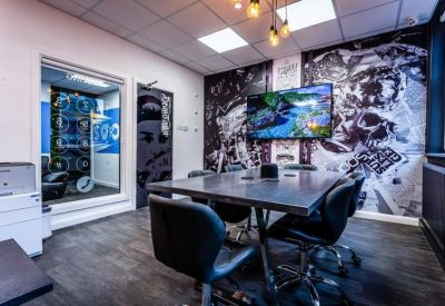 Modern meeting room with a large table, black chairs, and graphic monochrome wall art.