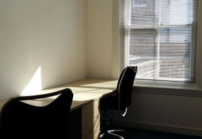 Private two-person office suite with natural light and blue carpeting.