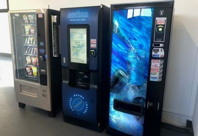 A row of snack and beverage vending machines in a communal area.