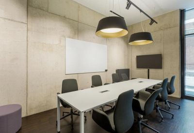 Professional meeting room with a long white table, ergonomic chairs, and a whiteboard.