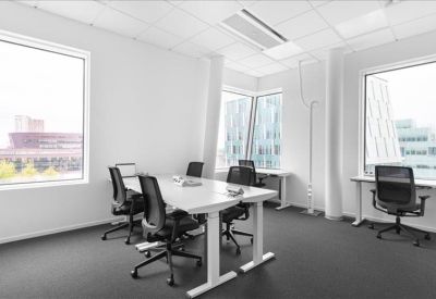 Bright corner office suite with floor-to-ceiling windows and white desks.