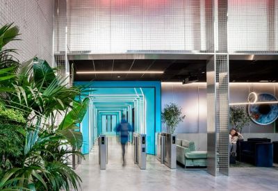 Modern lobby entrance with glass security turnstiles and vibrant blue accents.