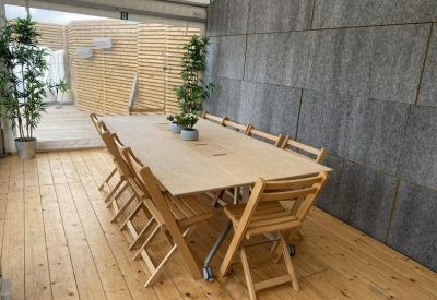 Casual meeting room with a large wooden table and folding chairs.