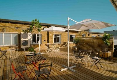 Spacious rooftop terrace with wooden decking and white parasols.