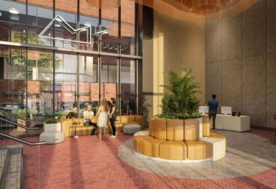 Spacious reception area with circular tiered seating, indoor plants, and large glass windows.