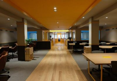 Spacious open-plan office with timber floors and dimmable recessed lighting.