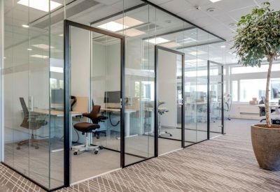 Sleek individual glass-enclosed office pods with ergonomic chairs and desks.