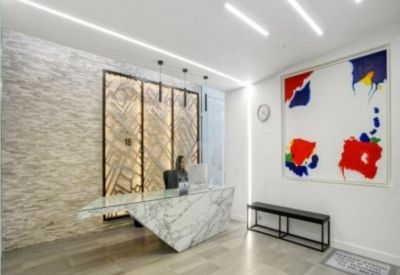 Modern reception area with a marble desk, textured stone wall, and colourful abstract art.
